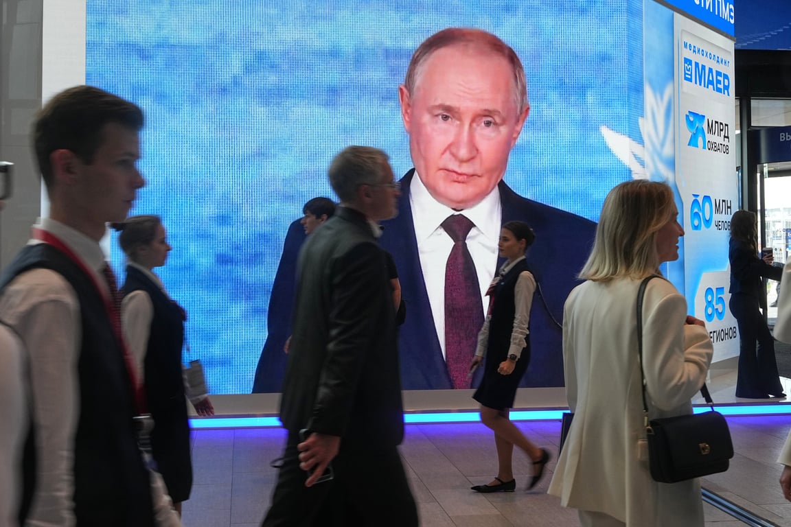 Участники ПМЭФ-2026 проходят мимо экрана с изображением Владимира Путина, Санкт-Петербург, 3 июня 2026 года. Фото: Дмитрий Ловецкий / AP / Scanpix / LETA