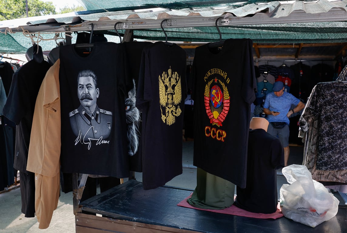 Футболки с изображением Сталина и гербами России и СССР на уличном рынке в Мариуполе, Донецкая область, Украина, 6 августа 2025 года. Фото: Александр Ермоченко / Reuters / Scanpix / LETA