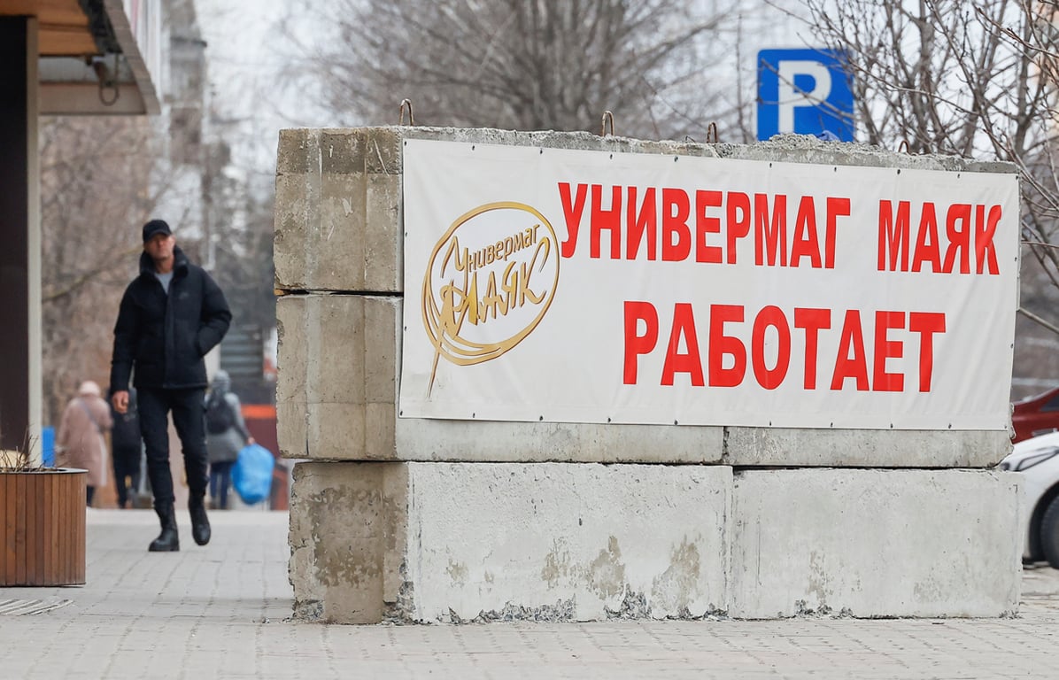 Прохожий идёт рядом с защитными барьерами из бетонных блоков, установленными у универмага в центре Белгорода, 10 марта 2024 года. Фото: Максим Шеметов / Reuters / Scanpix / LETA