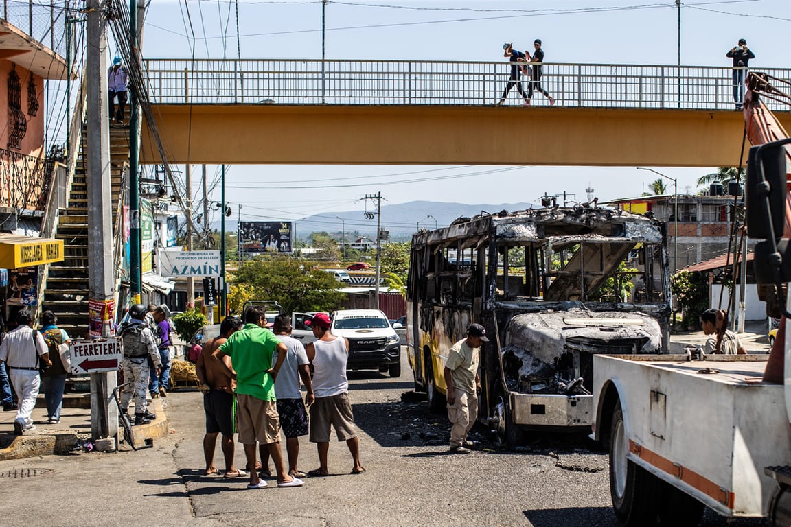 Люди осматривают автобус, сожженный предполагаемыми членами организованных преступных группировок в курортном городе Акапулько, Мексика, 22 февраля 2026 года. Фото: David Guzmán / EPA