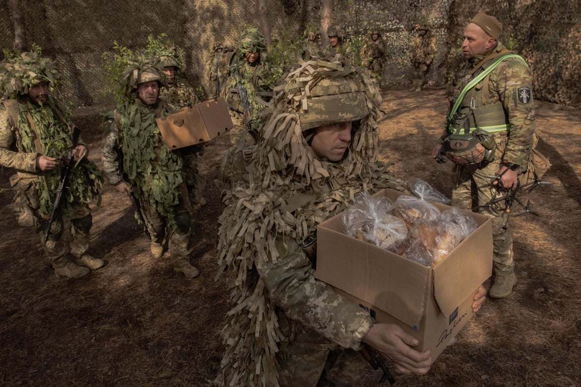 Военнослужащий ВСУ несет коробку с пасхальными куличами и продуктами после праздничного богослужения, Харьковская область, Украина, 12 апреля 2026 года. Фото: Roman Pilipey / AFP / Scanpix / LETA