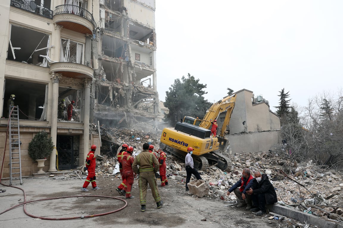 Иранские пожарные и официальные лица на месте разрушенного жилого дома в северной части Тегерана, 23 марта 2026 года. Фото: Abedin Taherkenareh / EPA