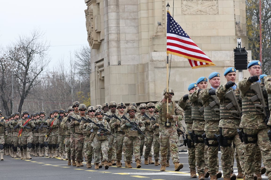 Американские военнослужащие маршируют с флагом США во время парада по случаю Дня Великого объединения Румынии в Бухаресте, Румыния, 1 декабря 2025 года. Фото: Robert Ghement / EPA