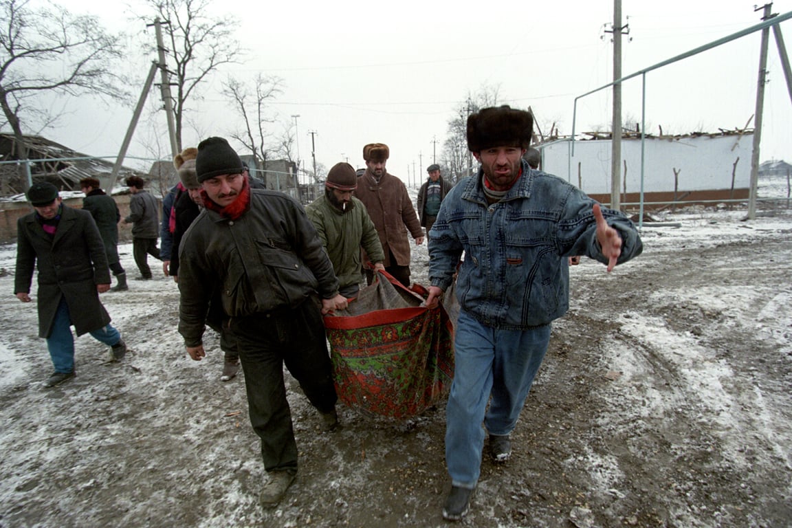 Местные жители несут тело погибшего заложника после штурма Первомайского, Дагестан, 19 января 1996 года. Фото: Сергей Чириков / EPA