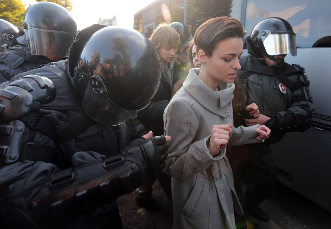 Police officers lead a gay rights activist away after clashes with anti-LGBT protesters in St. Petersburg, 12 October 2013. Photo: EPA / Anatoly Maltsev