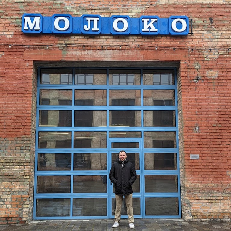 Леонид Мамашвили под отреставрированной вывеской «Молоко». Фото из личного архива героев