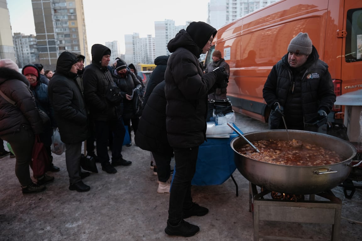 Сотрудник благотворительной организации раздаёт горячую еду жителям жилого района Киева, Украина, 17 января 2026 года. Фото: Maria Senovilla / EPA