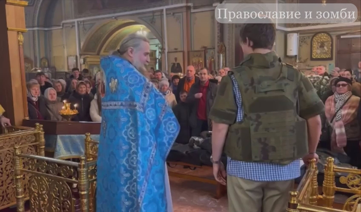 Протоиерей Виталий Кулешов, настоятель Преображенского храма в селе Саввино, демонстрирует бронежилет на подростке. Фото: «Православие и зомби» /  Telegram