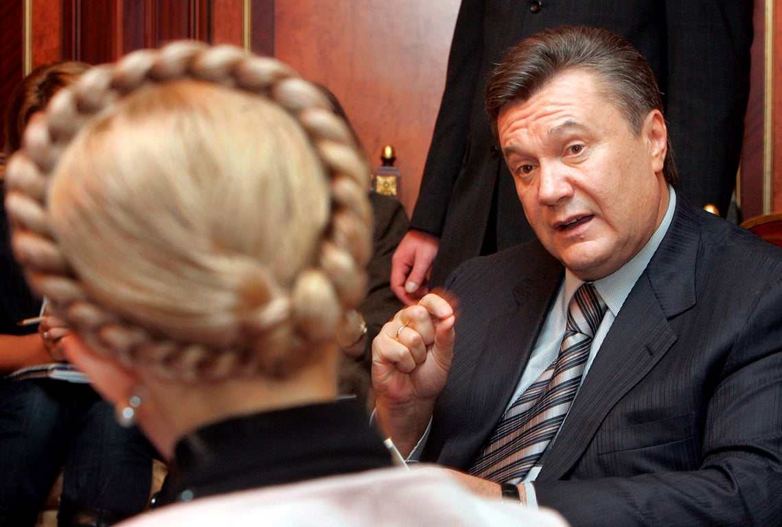 Бывший премьер-министр Украины Виктор Янукович беседует с исполняющей обязанности премьер-министра Украины Юлией Тимошенко во время их встречи в Киеве, Украина, 25 декабря 2007 года. Фото: Sergey Dolzhenko / EPA