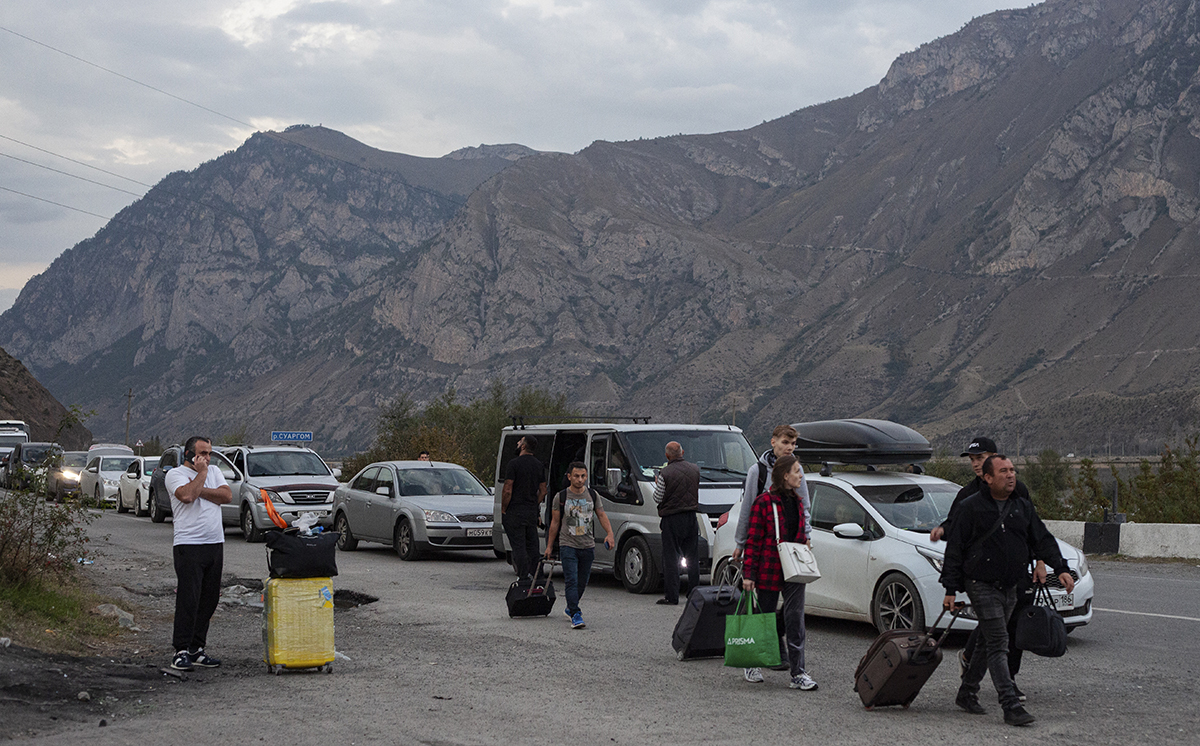 Российские мужчины и женщины с багажом проходят таможенный досмотр на российско-грузинском пограничном пункте пропуска Верхний Ларс, Россия, 30 сентября 2022 года. Фото: Ольга Юнашева / EPA
