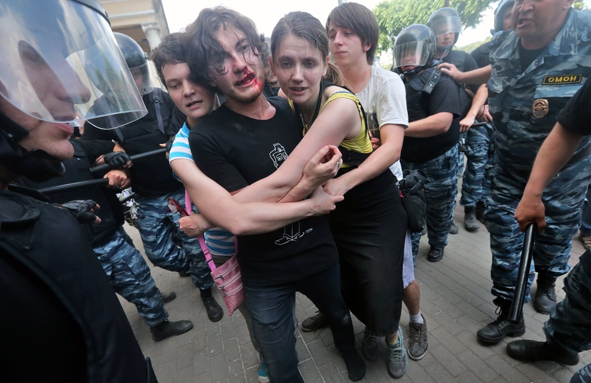 An injured gay rights activist is surrounded by police after being attacked at a Gay Pride event in St. Petersburg, 29 June 2013. Photo: EPA / Anatoly Maltsev
