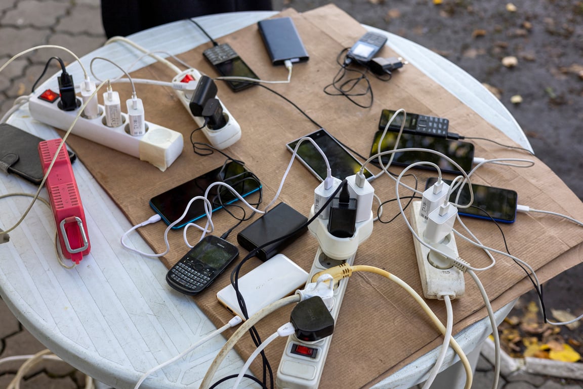 Местные жители заряжают телефоны от генератора у магазина в Балаклее, Харьковская область, Украина, 21 сентября 2022 года. Фото: Umit Bektas / Reuters / Scanpix / LETA