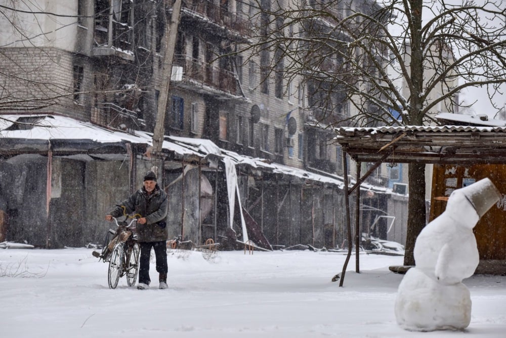 A man pushes his bicycle through the streets of Siversk, on 18 February 2023. Photo: EPA/OLEG PETRASYUK