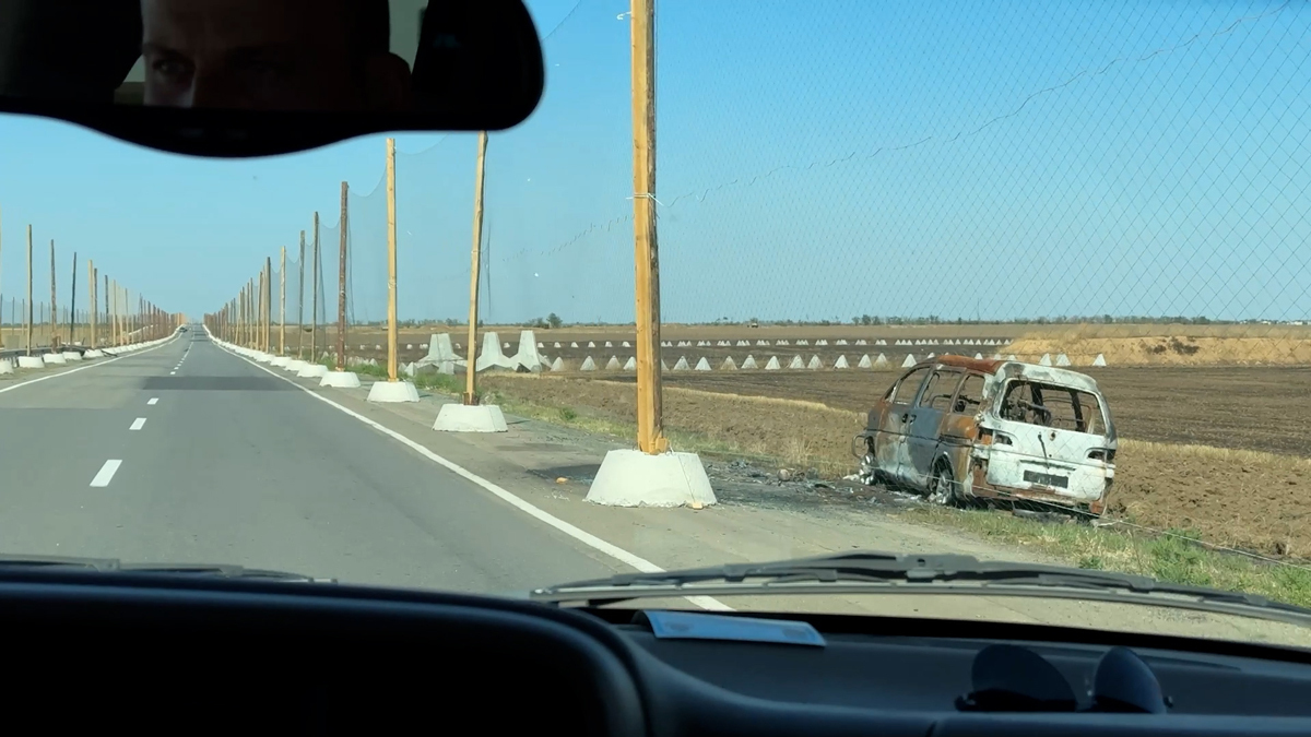 Сгоревшее авто после атаки FPV-дрона на трассе Николаев-Херсон. Фото: Дарья Литовченко / «Новости Донбасса»