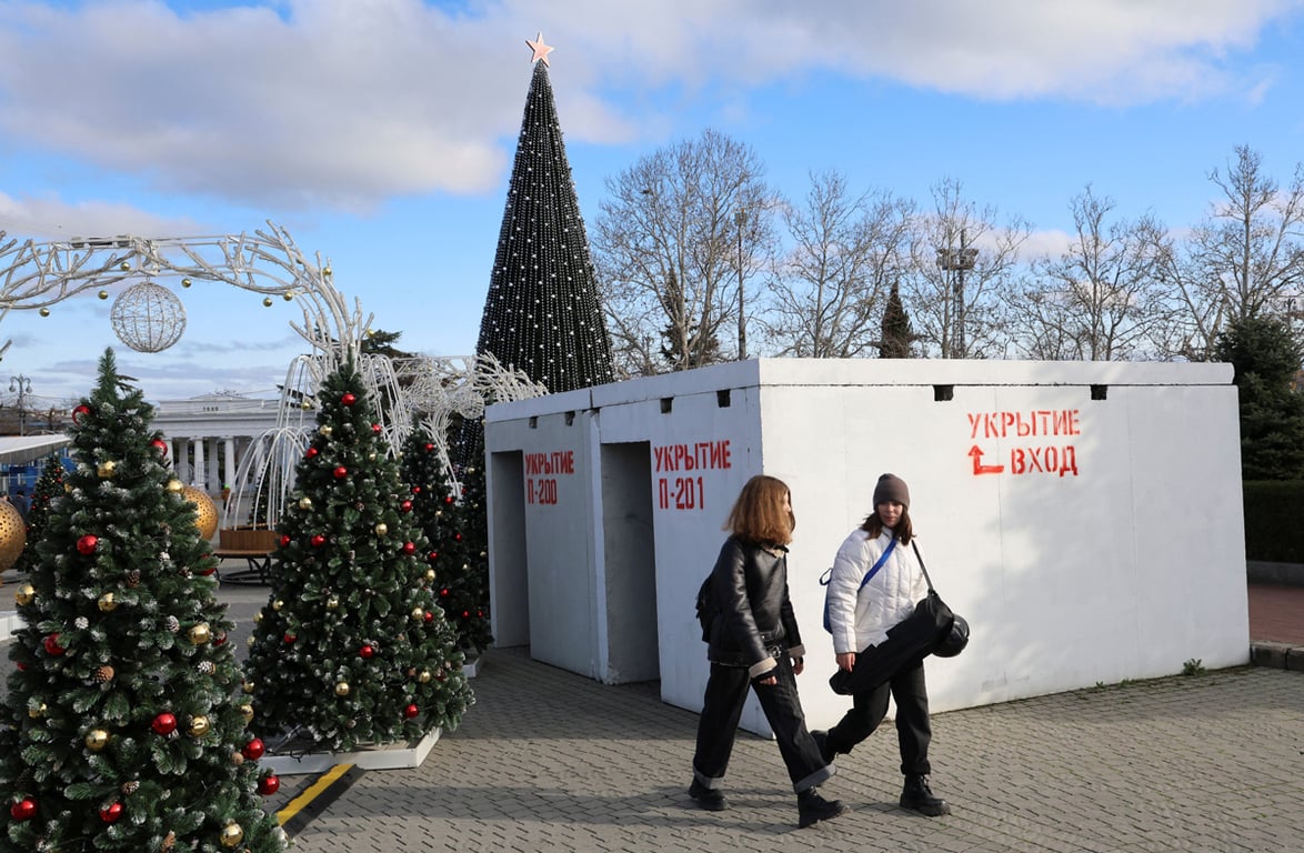 Люди проходят мимо новогодних украшений и бомбоубежища, Севастополь, Украина, 27 декабря 2024 года. Фото: Алексей Павлишак / Reuters / Scanpix / LETA