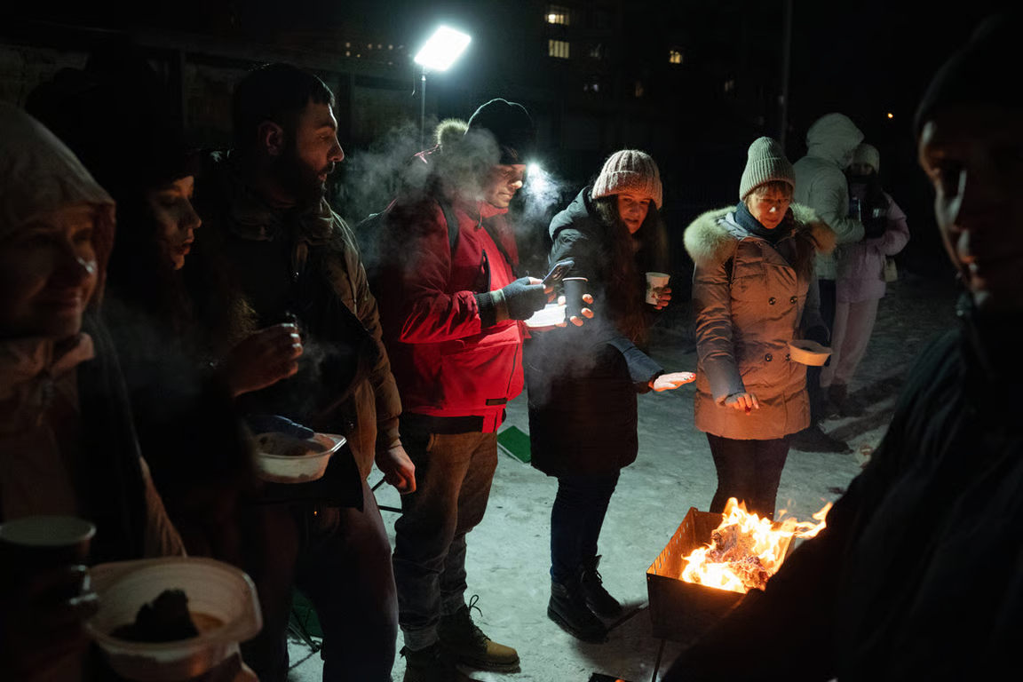 Locals in the Poznyaky district, on the left bank of the Dnipro, grill food in their courtyard under floodlights during a prolonged power and heating cut, Kyiv, Ukraine, 18 January 2026. Photo: Danylo Antonyuk / Ukrinform / Sipa / Scanpix / LETA