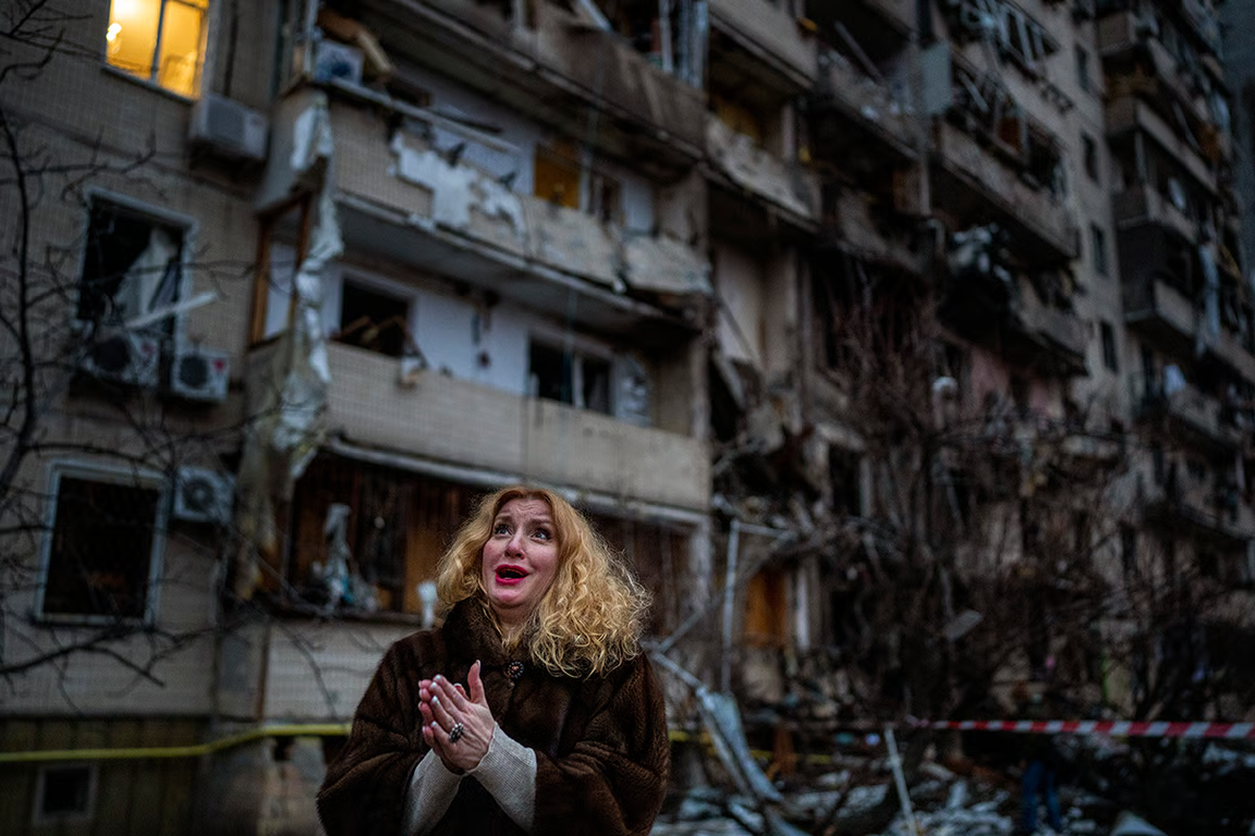 A woman watches as her home in Kyiv is destroyed in a fire caused by a missile strike, 25 February 2022. Photo: Emilio Morenatti / AP / Scanpix / LETA