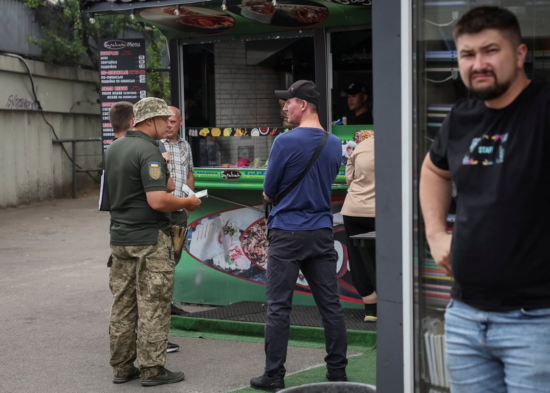 Проверка военно-учетных документов у мужчины на улице в Киеве, Украина, 3 июля 2024 года. Фото: Gleb Garanich / Reuters / Scanpix / LETA