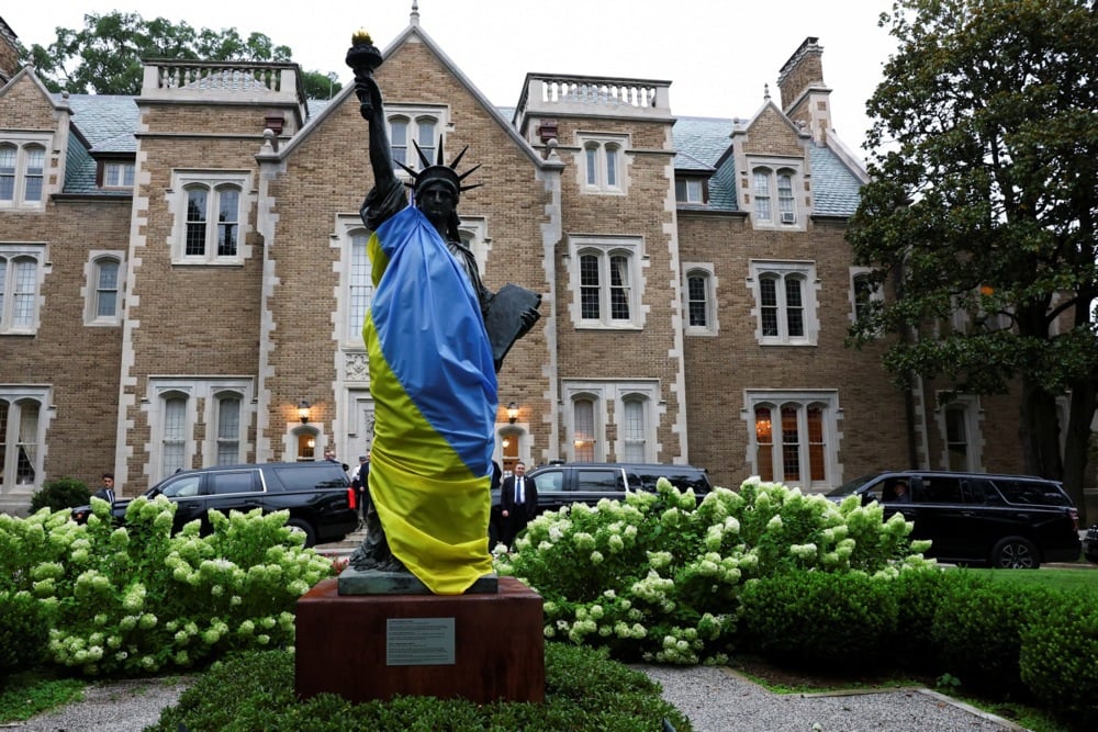 A scaled model of the Statue of Liberty is displayed draped in a Ukrainian flag in the gardens of the French Embassy in Washington, DC, USA, 18 August 2025. Photo: EPA / YVES HERMAN / POOL
