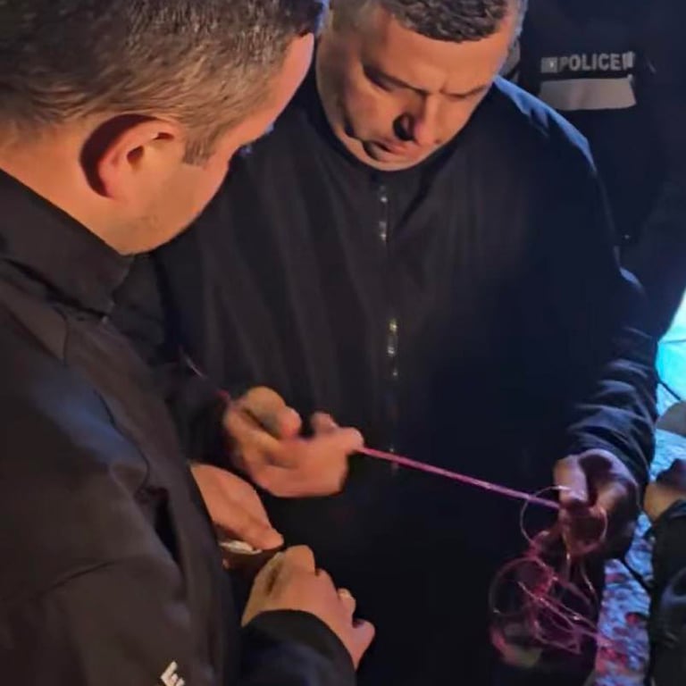 Полицейские закрывают розовой лентой пакет с масками. Фото: Nancy Woland /  Facebook