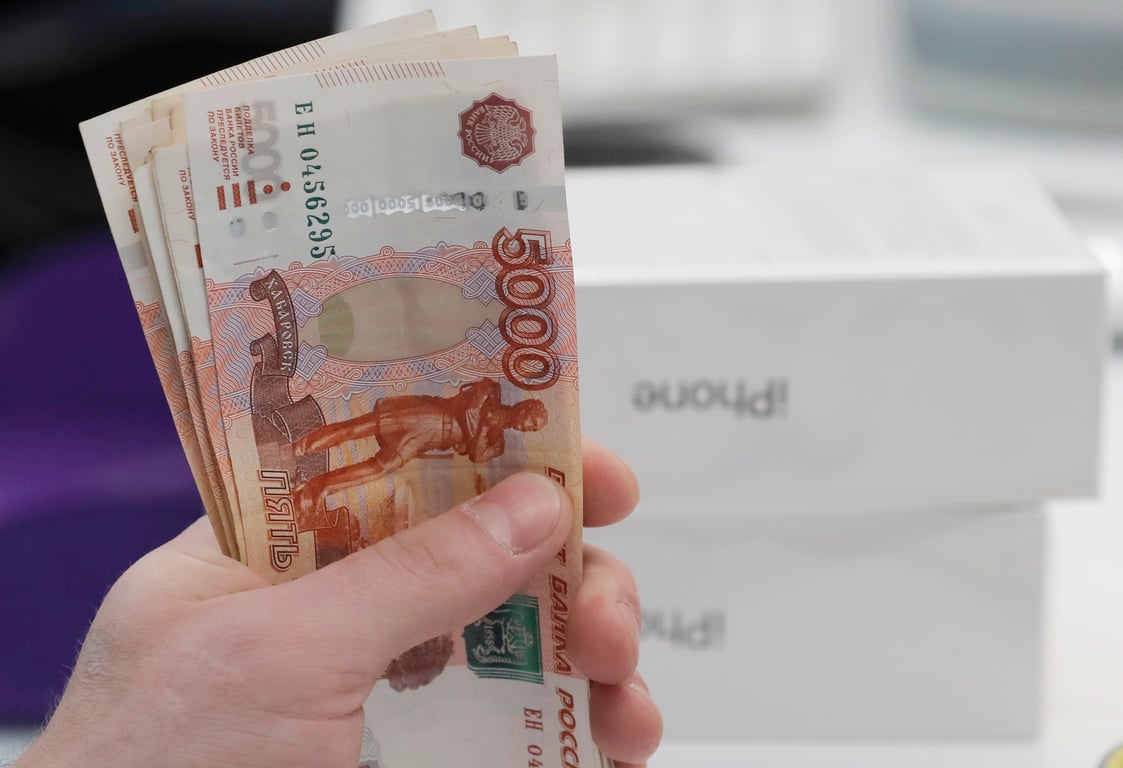 A customer pays in cash for a new iPhone in Moscow. Photo: EPA / SERGEI ILNITSKY