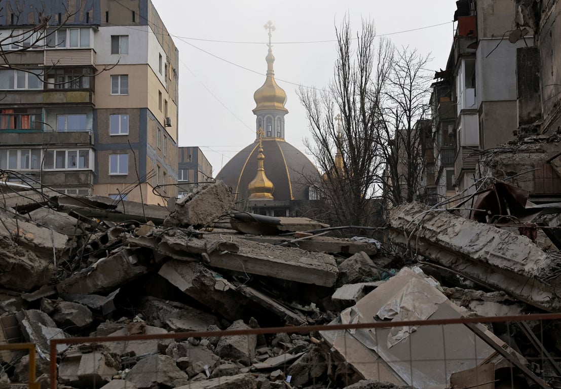 Вид на купол православного храма за зданием, разрушенным в ходе российского вторжения в Украину, Мариуполь, Донецкая область, 24 декабря 2022 года. Фото: Александр Ермоченко / Reuters / Scanpix / LETA