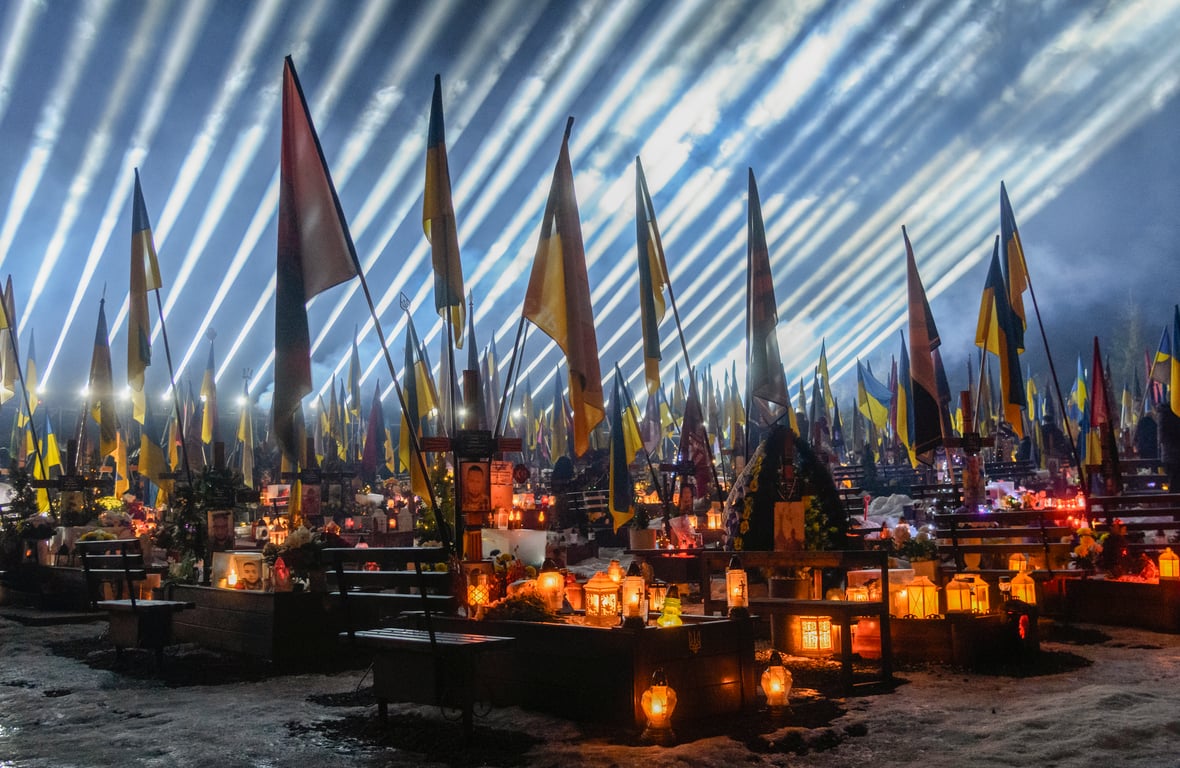 Beams of light illuminate the sky over the graves of fallen Ukrainian soldiers during a candlelight vigil at Lychakiv Military Cemetery in Lviv, western Ukraine, 23 February 2026. Photo: EPA / Mykola Tys