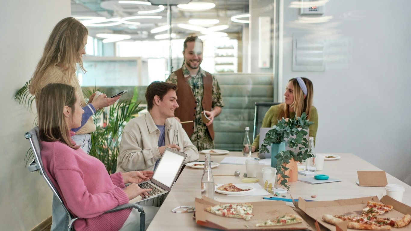 Employees having a chat at lunch over pizza