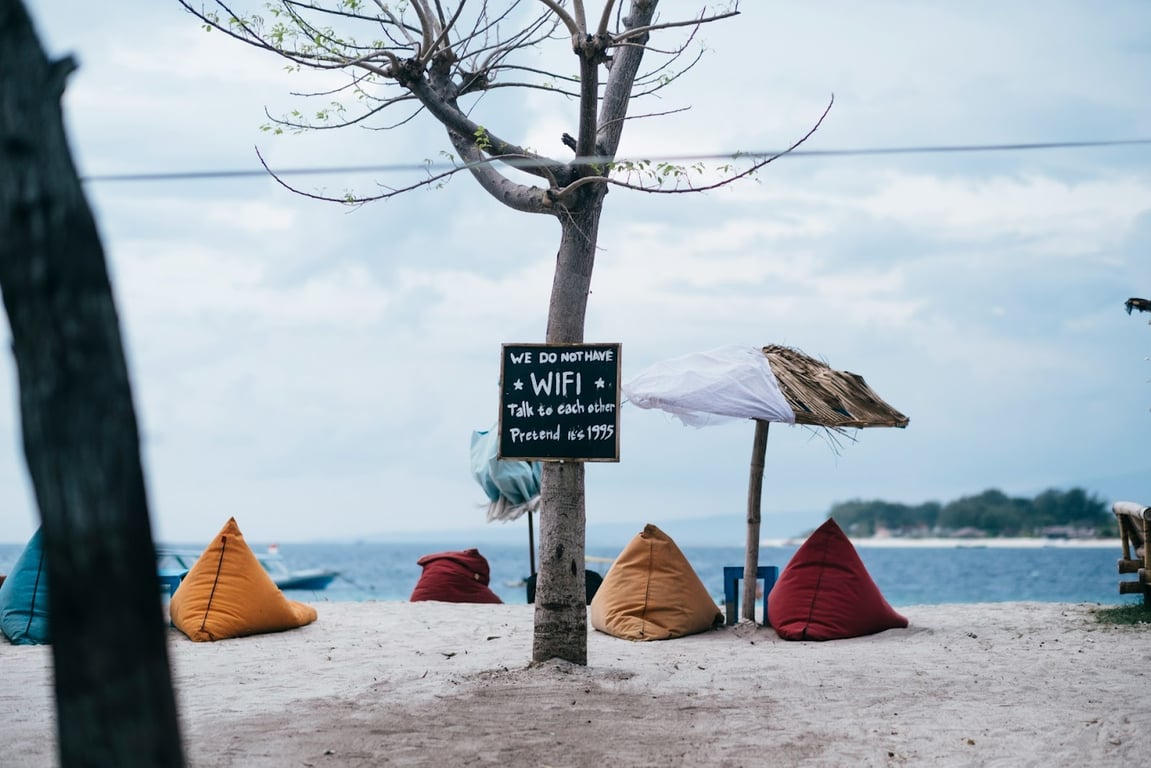 A beach with a sign saying they don’t offer Wifi
