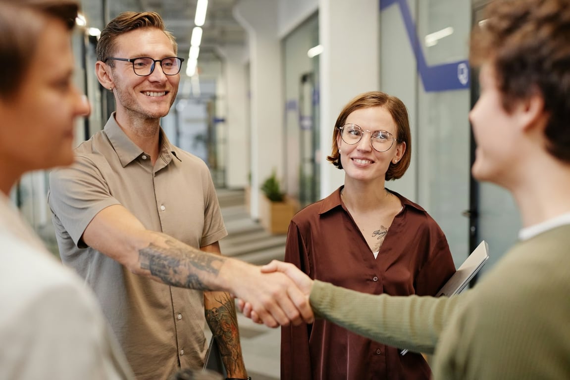Several happy employees shaking hands with a positive culture workplace