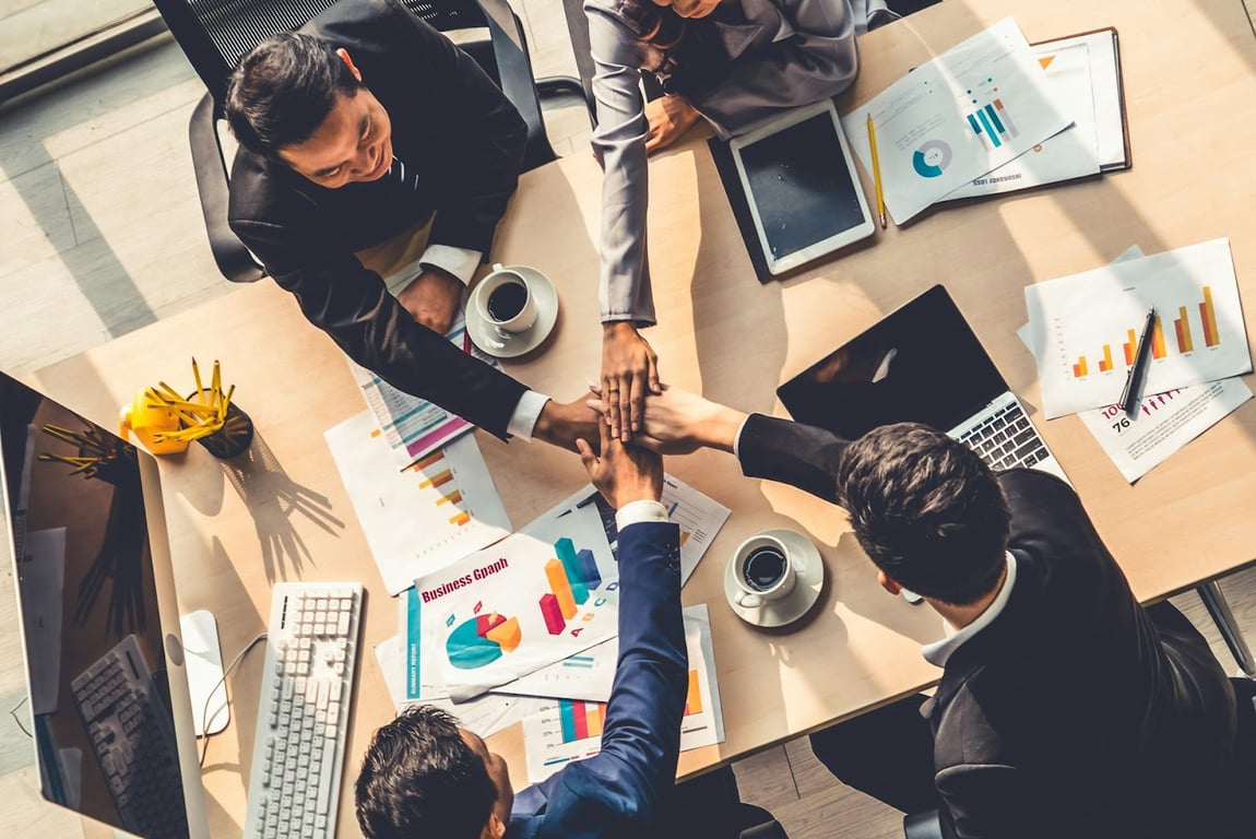 A group of office people shaking hands after a good day