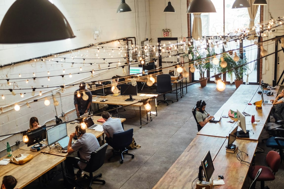 A top-down view of a tech office with people working at desks