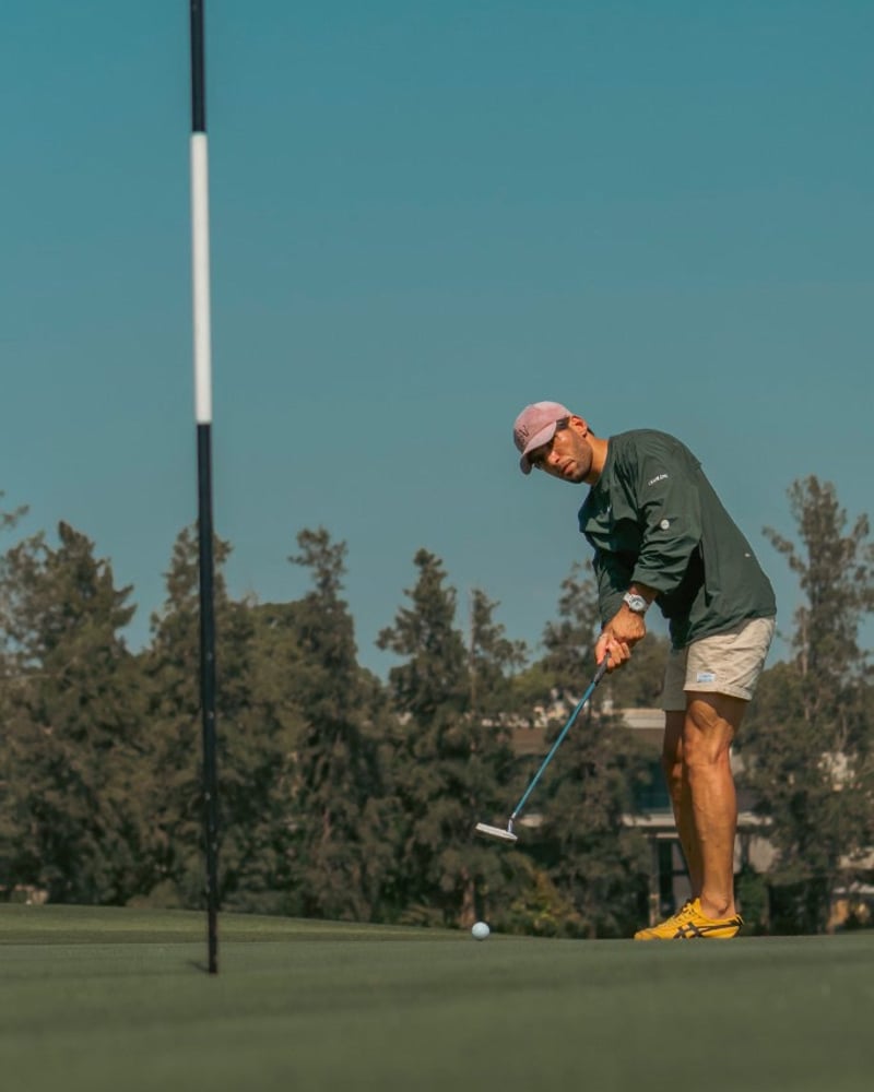 Golfer putting on a sunny green — returning to an active life after spine care
