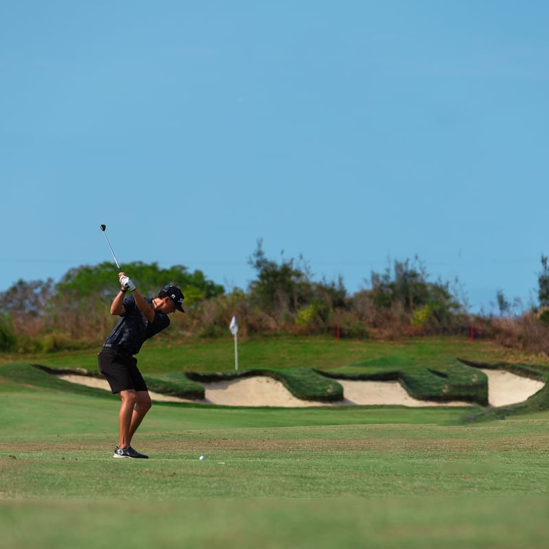 Golfer preparing to hit a ball on a sunny course