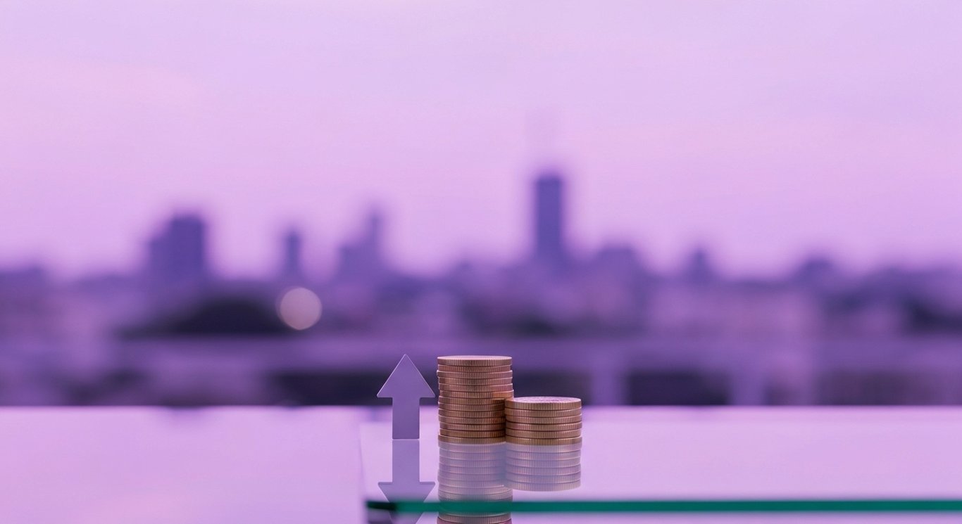Upward arrow beside stacked coins on glossy desk with soft purple gradient background