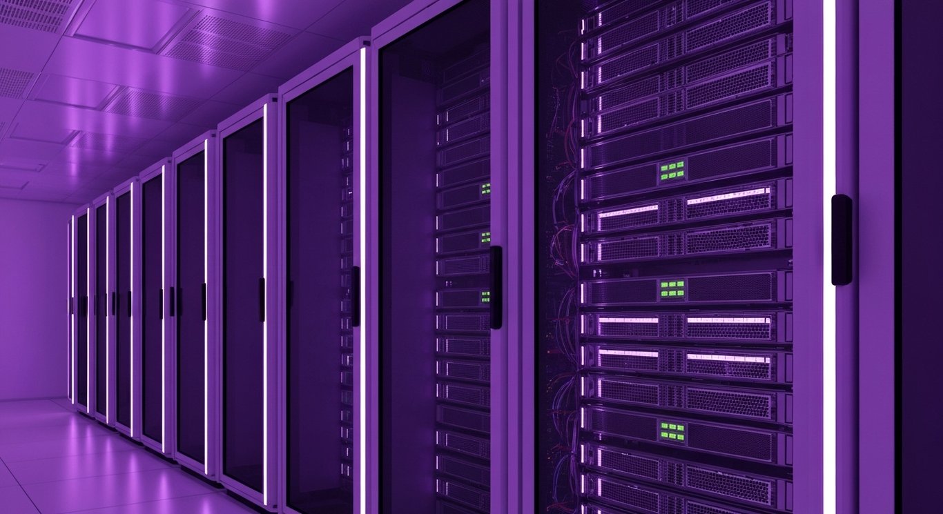 Data server racks in a modern data center illuminated by soft purple lighting