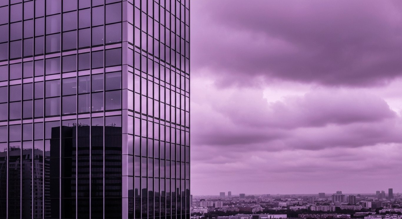 Modern skyscraper with reflective glass set against a city skyline and soft purple tones