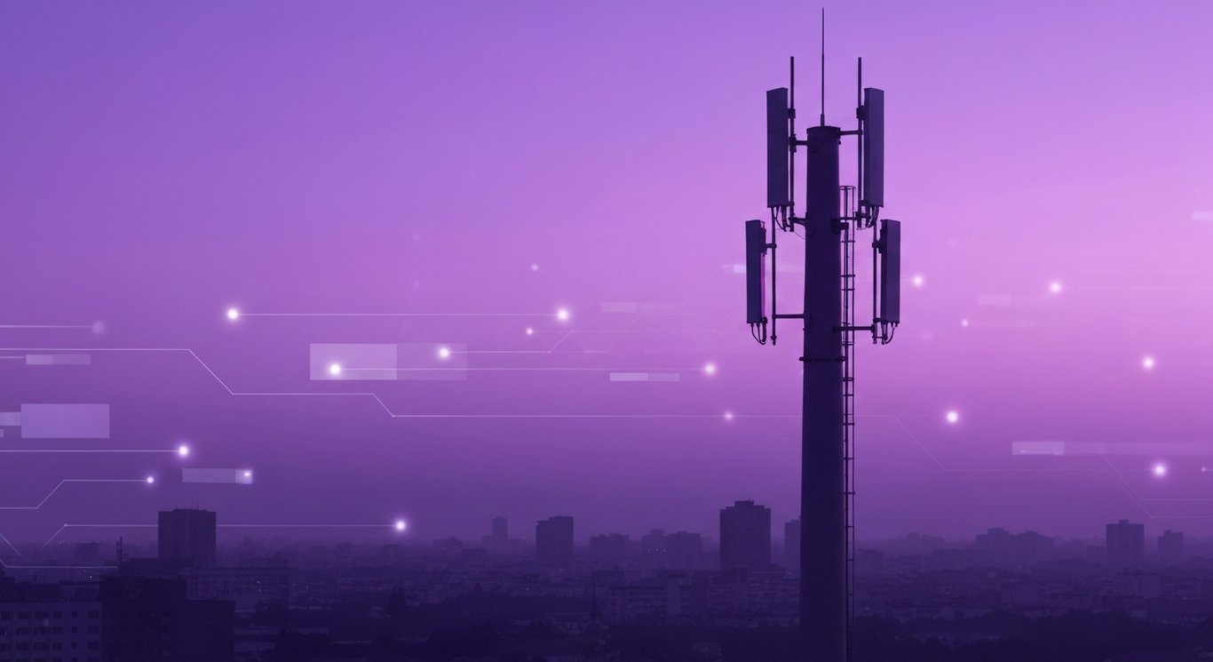 Mobile communication tower in front of a city skyline with a soft purple-toned backdrop