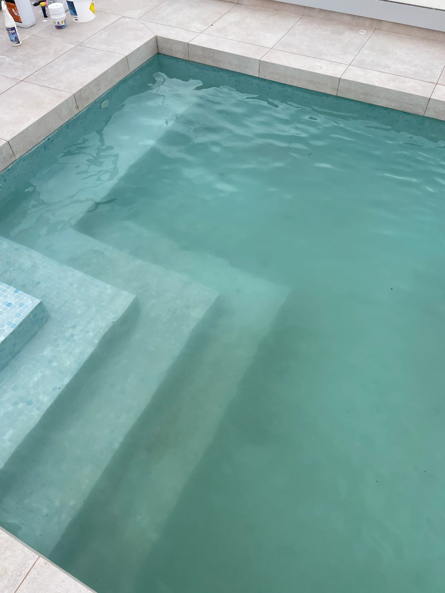 Pool steps and floor covered in dirt