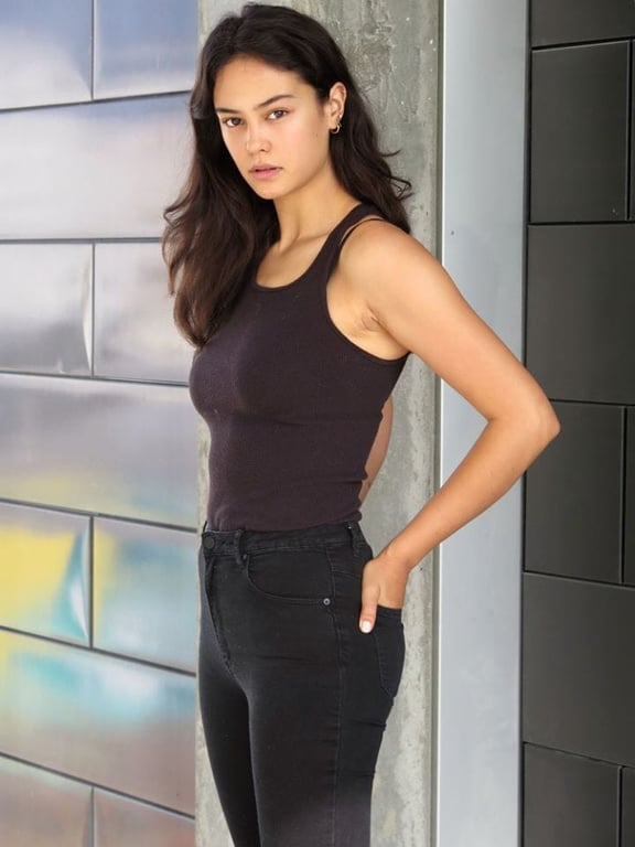 Courtney Eaton wearing a black top while gives a side pose