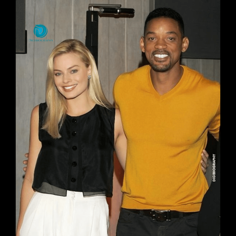 Margot Robbie stands with will smith and wears a black and white dress