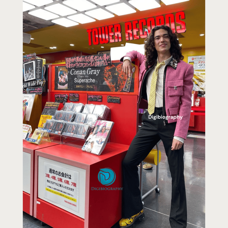 Conan Gray standing in a store nearby his book section in tower records