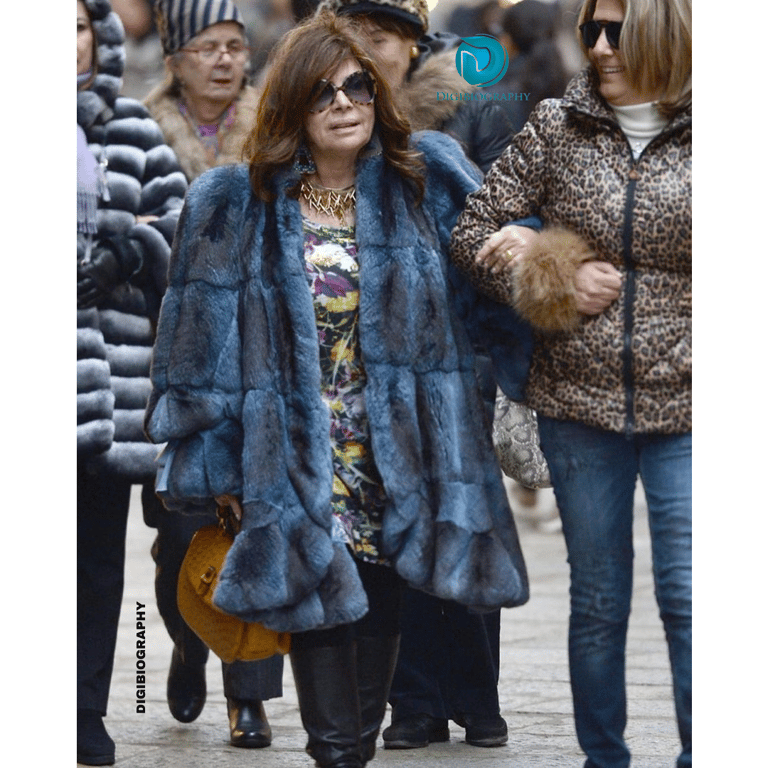 Patrizia Reggiani walking with her friend and wearing a blur dress