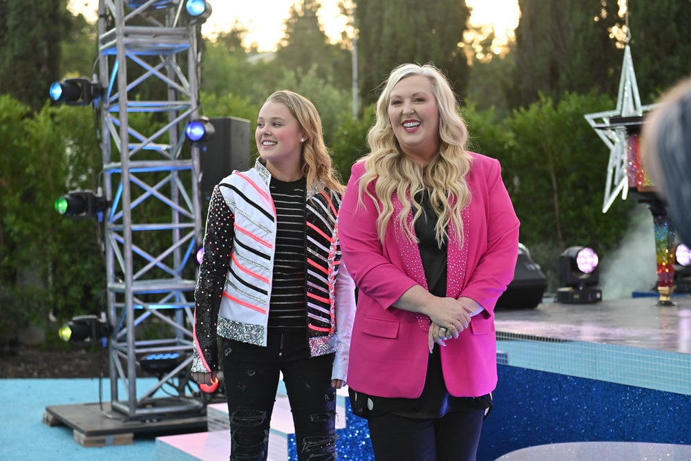 Jessalynn Siwa and their daughter standing in the shooting area while wearing a pink jacket