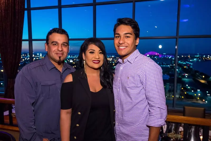 Suzette Quintanilla standing with brother in black dress