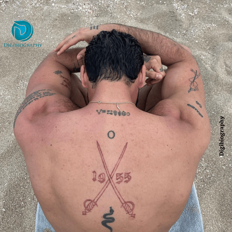 Michele Morrone showing his tattoo in his beck at the beach