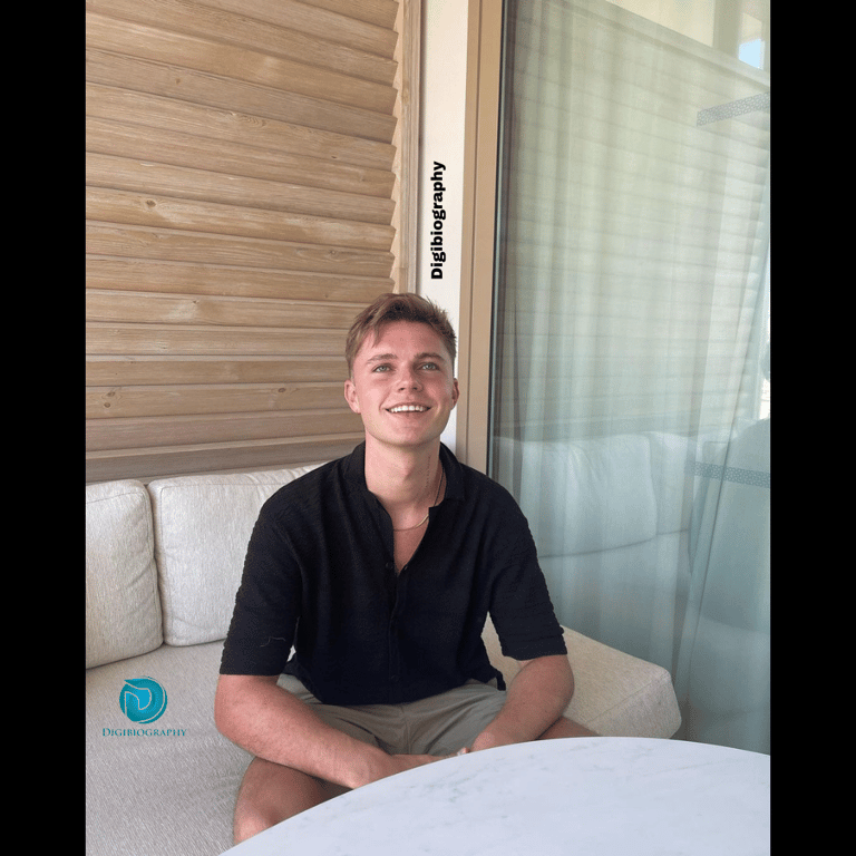 HRVY sitting on the white sofa while wearing a black t-shirt