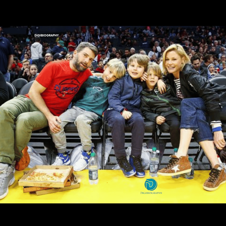 Julie Bowen sitting with her husband and her sons while wearing a black jacket and blue jeans