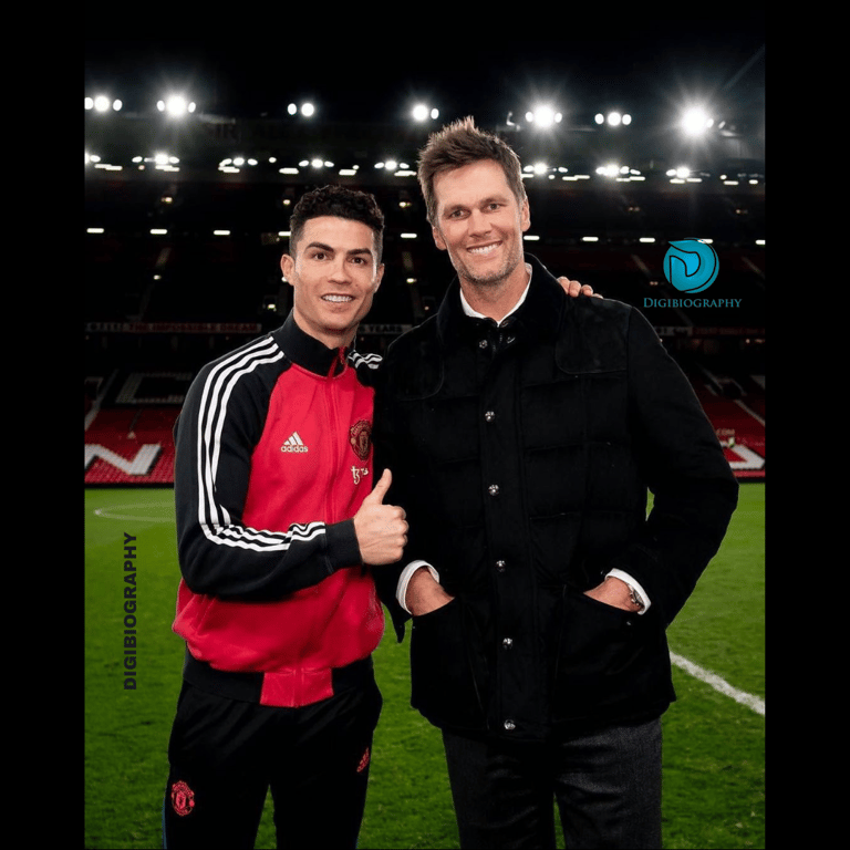 Cristiano Ronaldo stands in the stadium with her friend while wearing a red and black dress