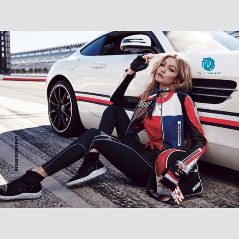 Gigi Hadid sitting on the race track with her car
